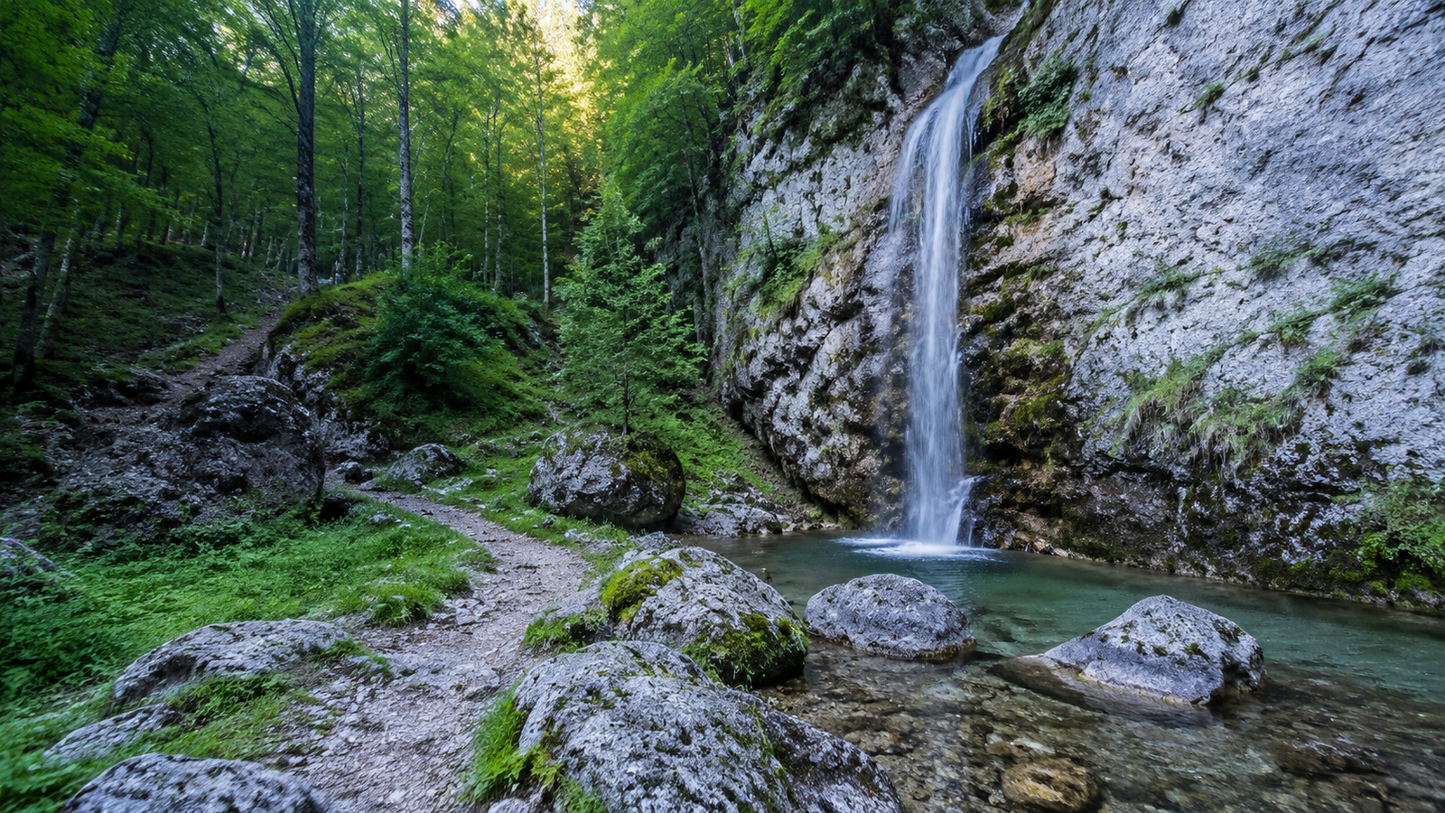 Clear turquoise Valbona River flowing beneath the peaks of the Albanian Alps