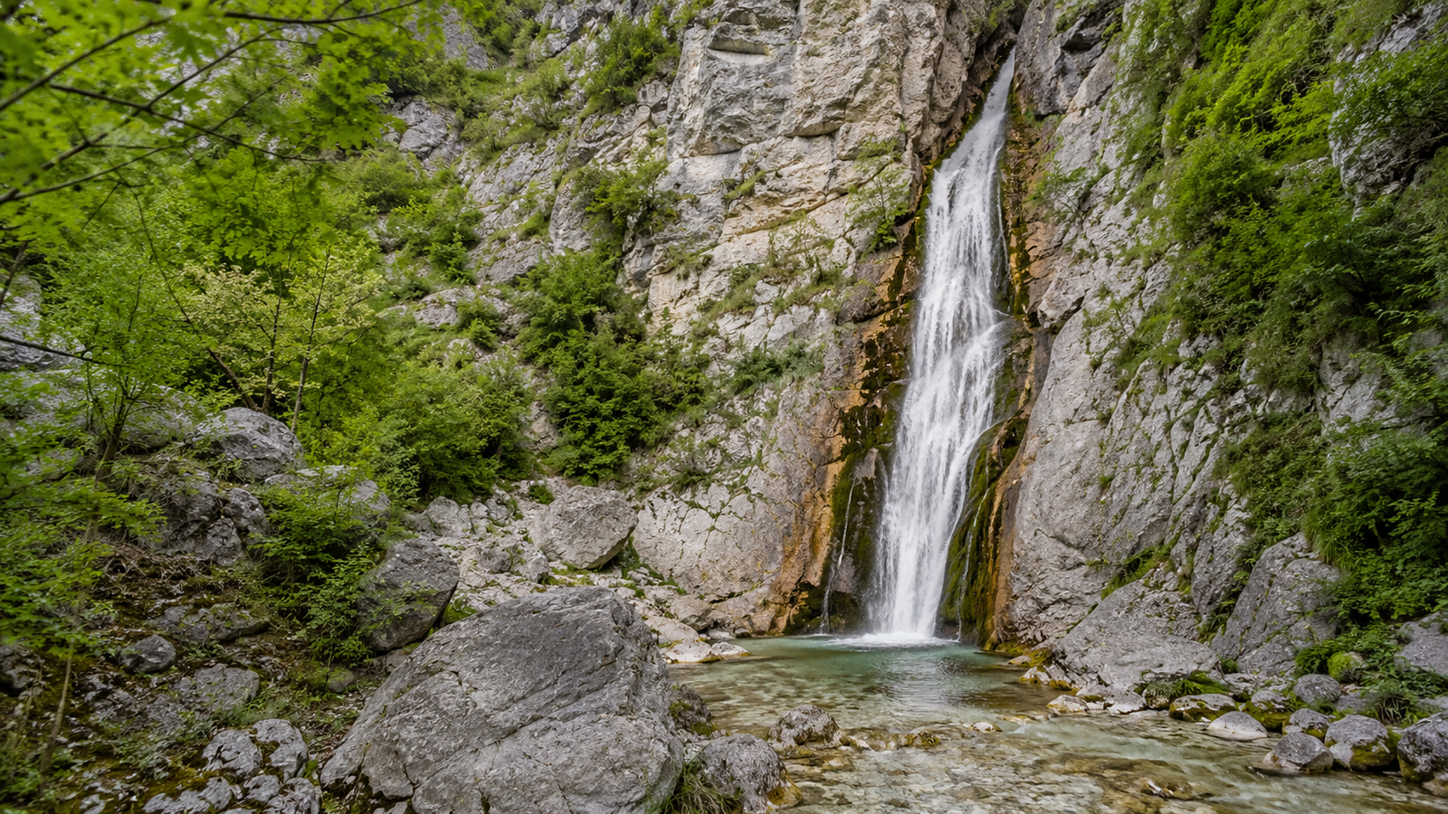 Grunas Waterfall flowing through a limestone gorge near Theth