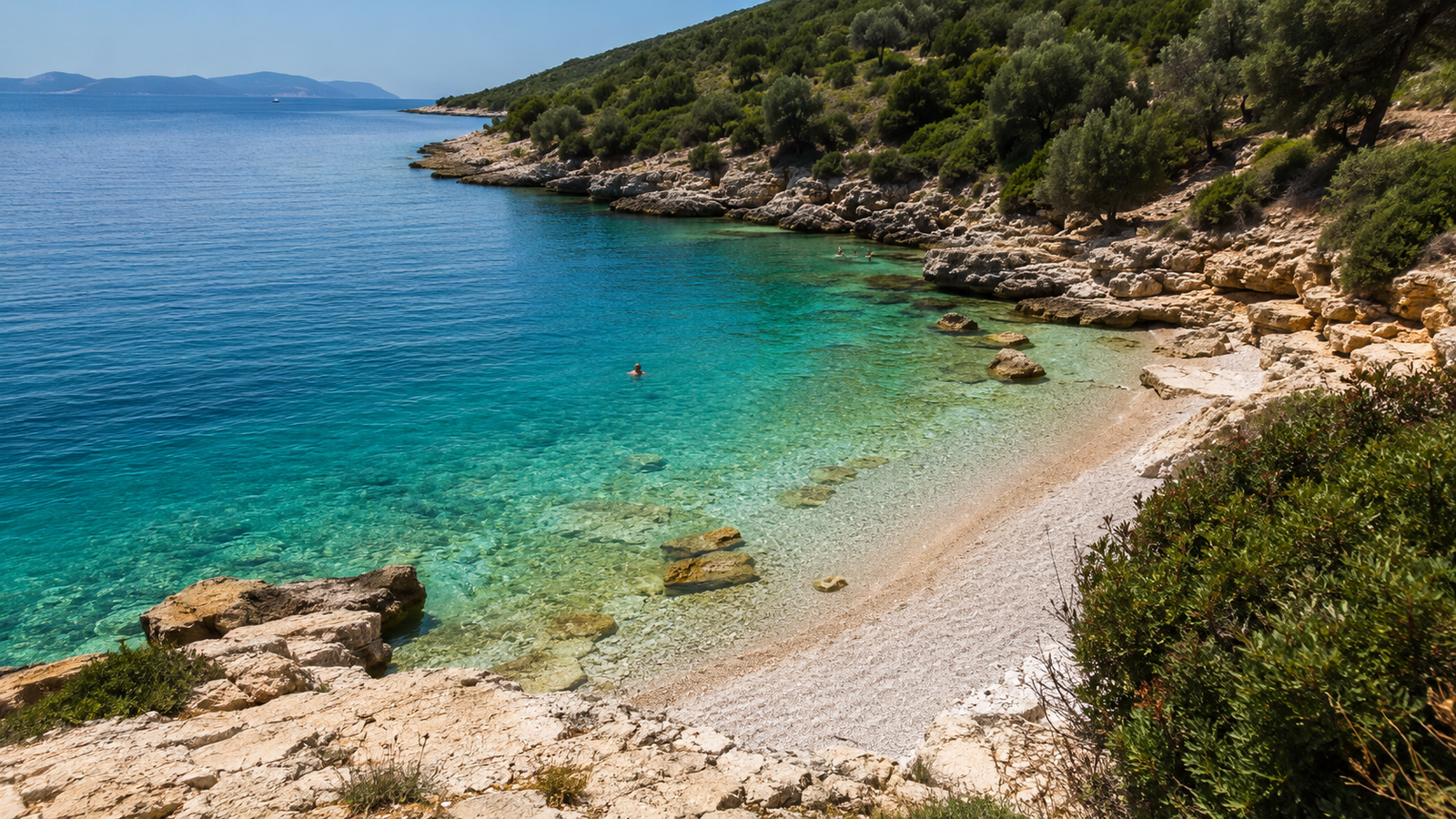 Mirror Beach near Ksamil with a quiet pebble shore and transparent water