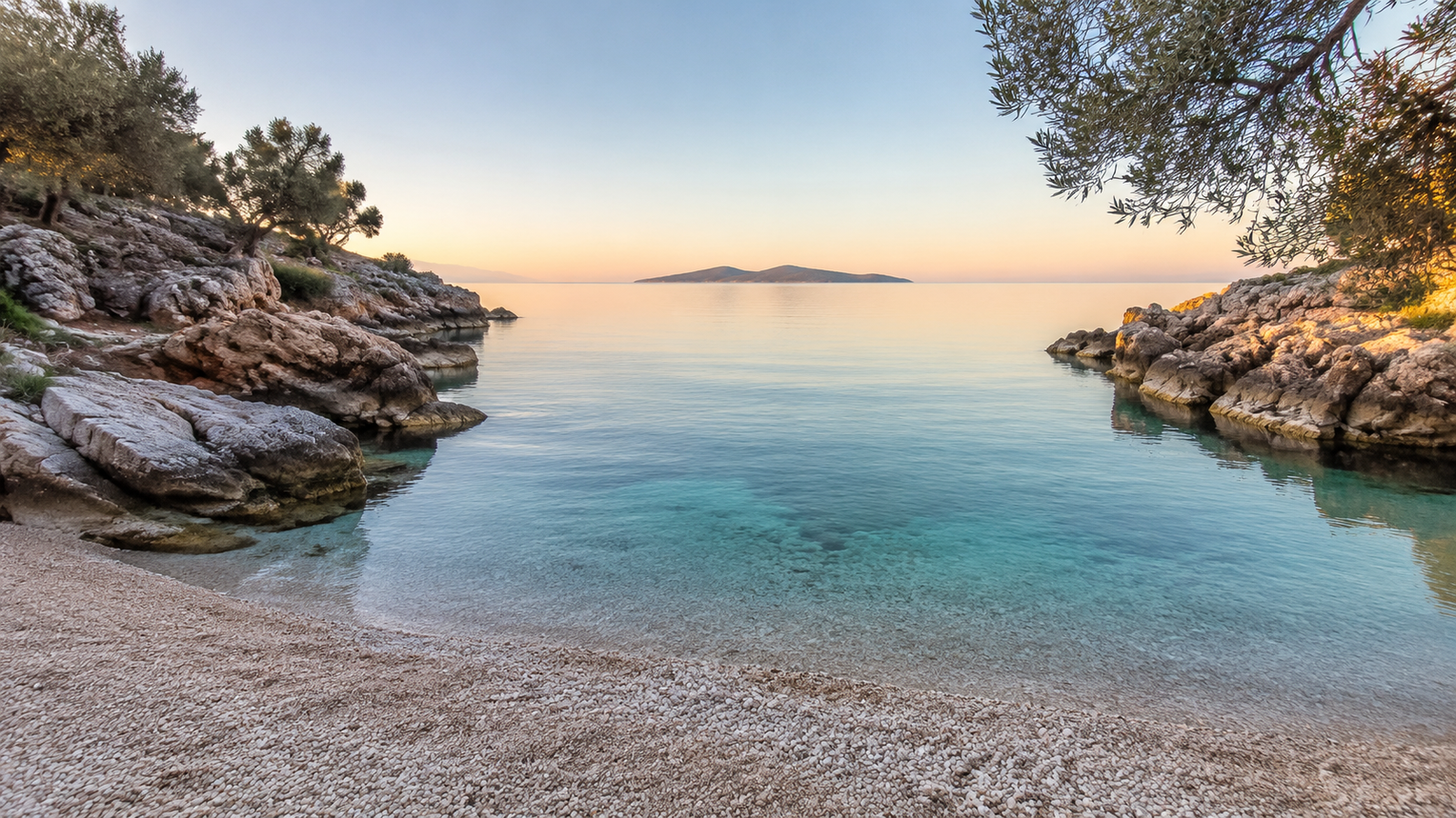 Peaceful rocky cove with transparent water near Ksamil at sunrise
